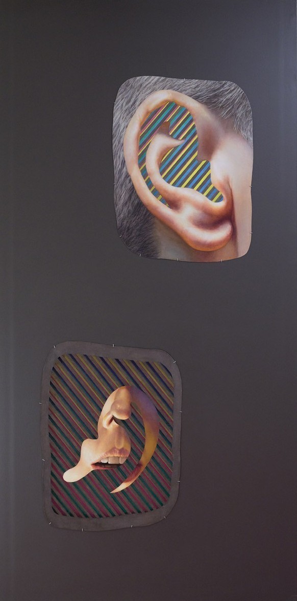 Grey wall with two cut-outs, one of an ear and one of a mouth. Bright blue and yellow stripes are inside the ears, and the mouth is surrounded by muted blue, yellow, and red stripes.